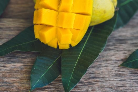 Mango and mango leaves on an old wooden background.