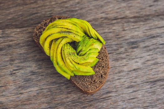 Avocado sandwich on dark rye bread made with fresh sliced avocados.