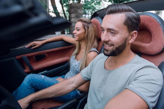 successful man sitting behind the wheel of a luxury car. the concept of a successful lifestyle