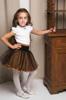 Little girl in the room with retro furniture of the last century. The concept of antiques, rarity, vintage.