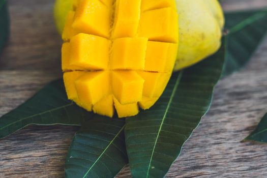 Mango and mango leaves on an old wooden background.