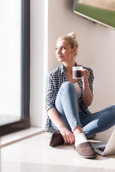 Real Woman Using laptop At Home on the floor Drinking Coffee Enjoying Relaxing