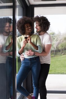 romantic happy young multiethnic couple enjoying morning coffee by the window in their luxury home