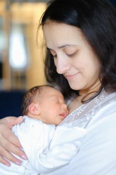 Young mother holding newborn baby. Concept of motherhood and babies.