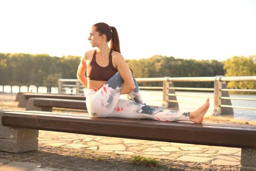 Young redhead sports woman make stretching yoga exercise outdoors