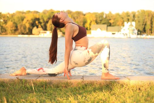 Young redhead sports woman make stretching yoga exercise outdoors