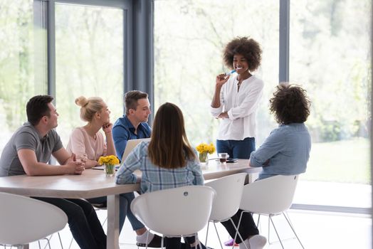 Multiethnic startup business team on meeting in modern bright office interior brainstorming, working on laptop and tablet computer