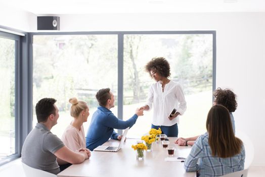 Multiethnic startup business team on meeting in modern bright office interior brainstorming, working on laptop and tablet computer