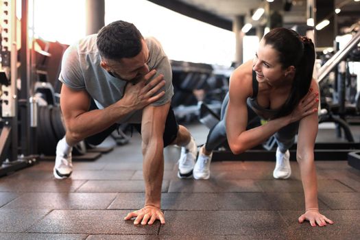 Portrait of beautiful young sports couple on a plank position