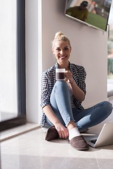 Real Woman Using laptop At Home on the floor Drinking Coffee Enjoying Relaxing