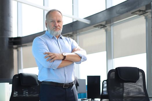 Confident pensive mature business man in modern office