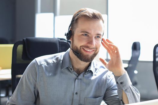 Smiling friendly handsome young male call centre operator