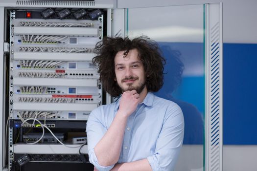 portrait of young handsome business man engeneer in datacenter server room