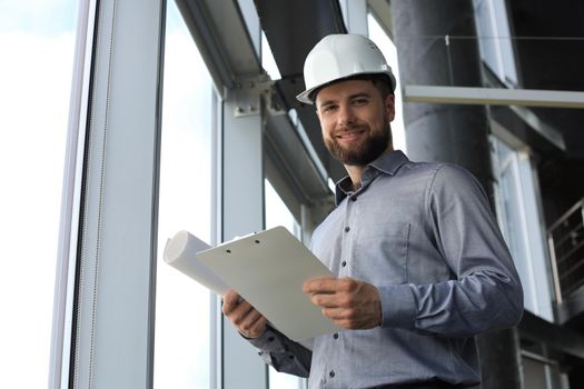Shot of male architect wearing hardhat and inspecting new building
