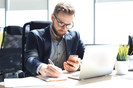 Businessman using his mobile phone in the office