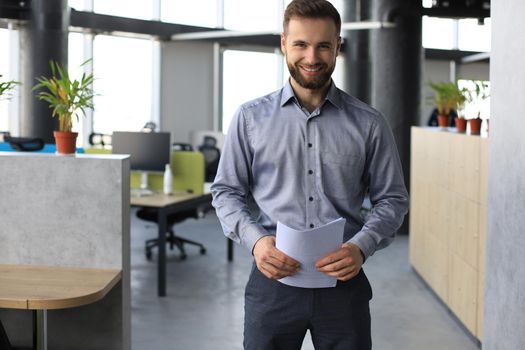 Young handsome businessman smiling in an office environment