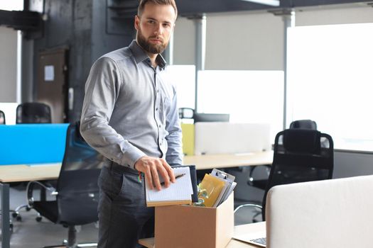 Sad dismissed worker are taking his office supplies with him from office