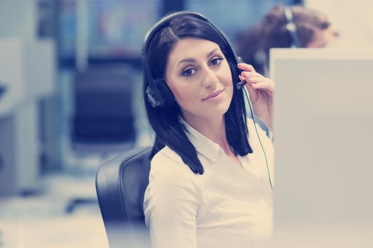 young smiling female call centre operator doing her job with a headset