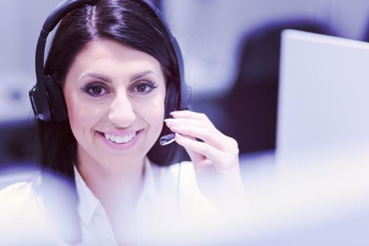 young smiling female call centre operator doing her job with a headset