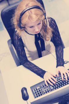 top view of a young smiling female call centre operator doing her job with a headset