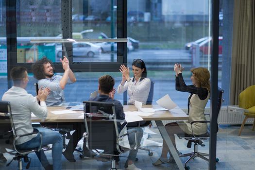 Group of young business people looking happy while celebrating success at their working places in startup office