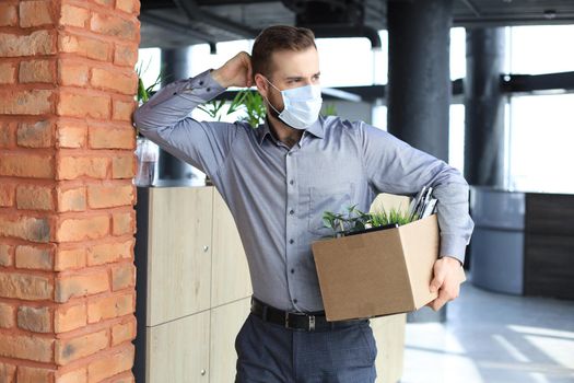 Dismissal employee in an epidemic coronavirus covid-19. Dismissed worker going from the office with his office supplies