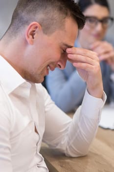 A time for relax. Young tired casual businessman relaxing at the desk in his office