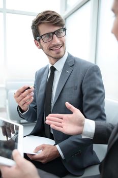 contemporary business people working connected with technological devices like tablet and laptop, talking together - finance, business, technology concept