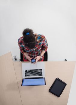 top view of young business woman working on laptop computer in modern bright startup office interior