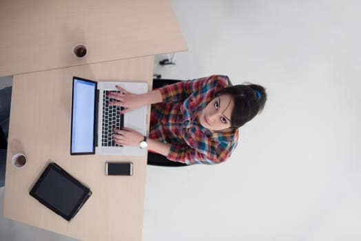 top view of young business woman working on laptop computer in modern bright startup office interior