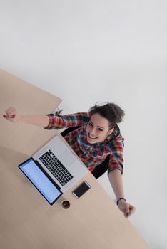 top view of young business woman working on laptop computer in modern bright startup office interior