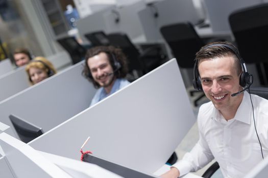 young smiling male call centre operator doing his job with a headset