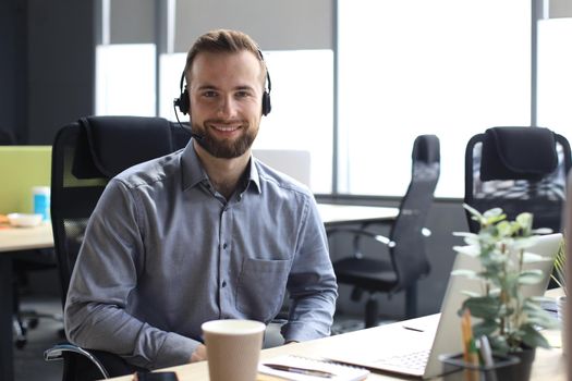 Smiling friendly handsome young male call centre operator