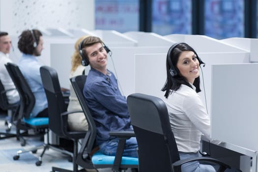 group of young business people with headset working and giving support to customers in a call center office