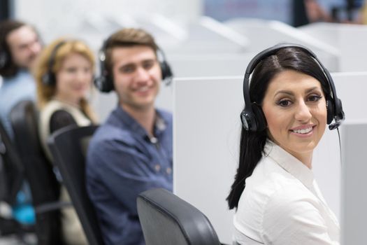 group of young business people with headset working and giving support to customers in a call center office