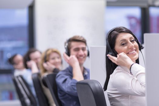 group of young business people with headset working and giving support to customers in a call center office