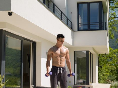 young handsome man doing morning exercises in front of his luxury home villa