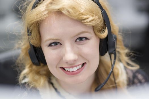 young smiling female call centre operator doing her job with a headset