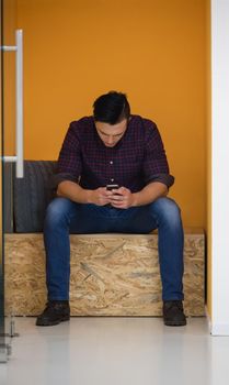 young man in crative box working on smart phone, startup business modern office room  interior