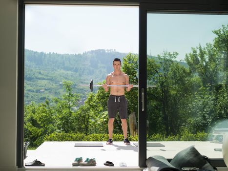 young handsome man doing morning exercises in front of his luxury home villa