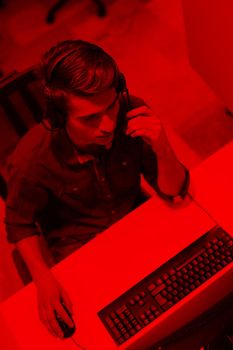 top view of a young smiling male call centre operator doing his job with a headset