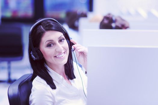 young smiling female call centre operator doing her job with a headset