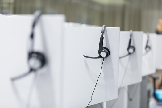 Headphones hanging on cubicle partition in empty call center office