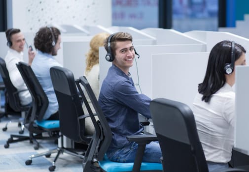 group of young business people with headset working and giving support to customers in a call center office