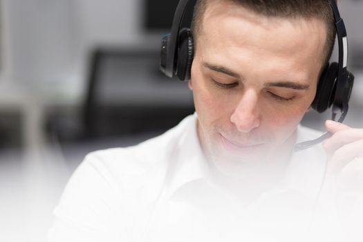 young smiling male call centre operator doing his job with a headset