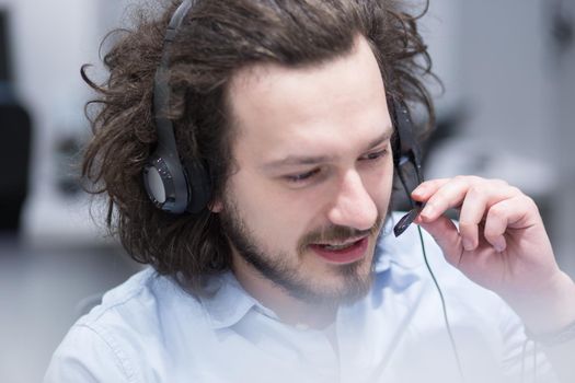 young smiling male call centre operator doing his job with a headset