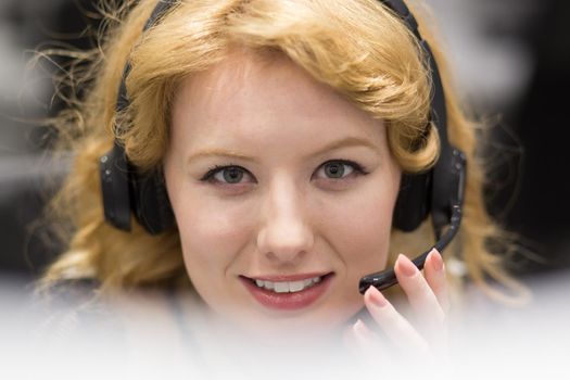 young smiling female call centre operator doing her job with a headset