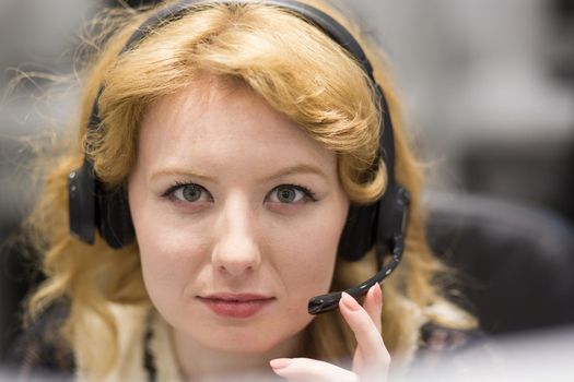 young smiling female call centre operator doing her job with a headset