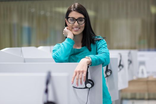 young smiling female call centre operator doing her job with a headset