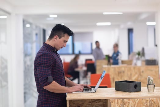 portrait of young businessman in casual clothes at modern  startup business office space,  working on laptop  computer